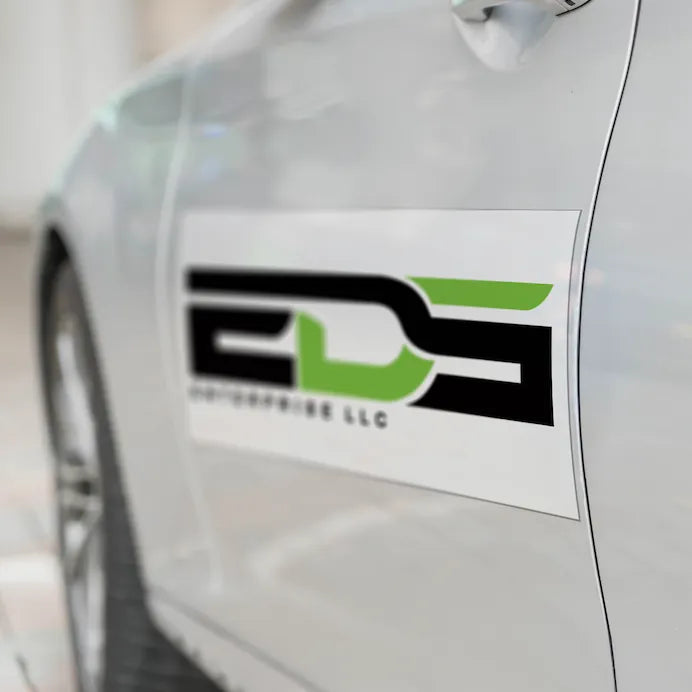 Custom printed magnetic vehicle sign featuring a business logo attached to the door of a white van, produced by Alison's Printshop in Mahwah, NJ.
