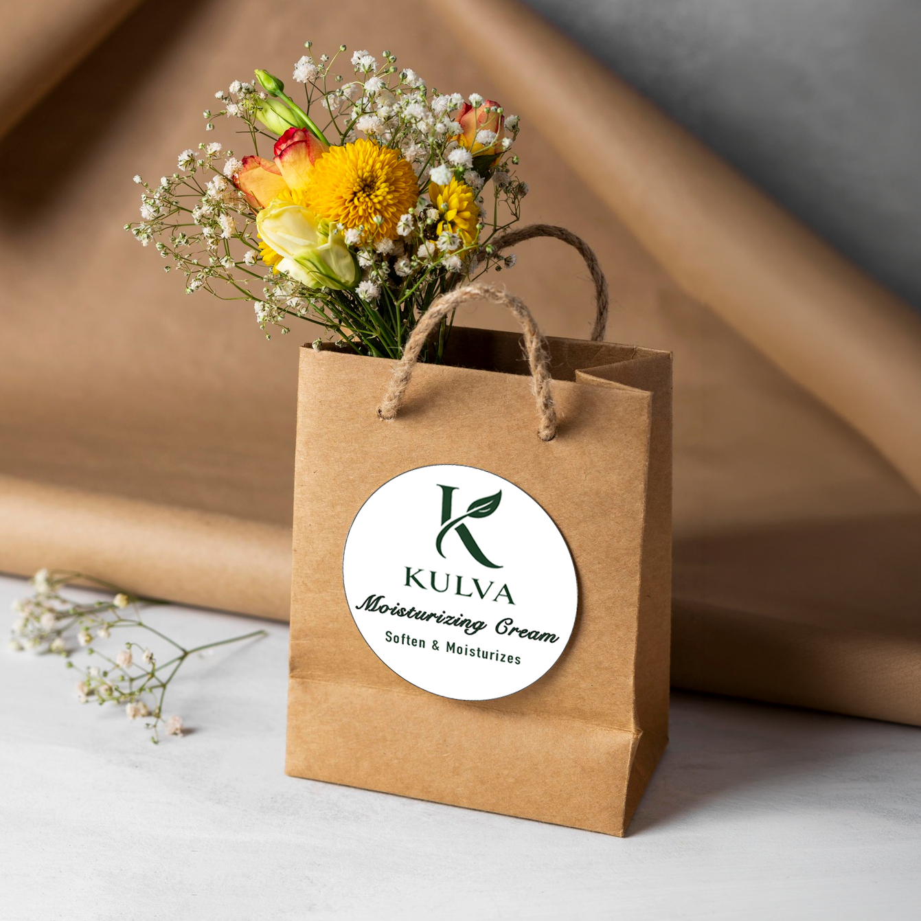 Custom round branding sticker for Kulva moisturizing cream applied to a brown paper gift bag, produced by Alison's Printshop.